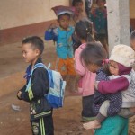 petite fille hmong à oudom xai qui porte son petit frère avec elle dans sa classe. Nous soutenons l'école , une école en dur.