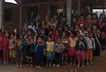 vous pouvez voir derrière l'école en dur en cours de construction, les enfants hmong lèvent la main, les autres enfants sont de l'ethnie Khamu.